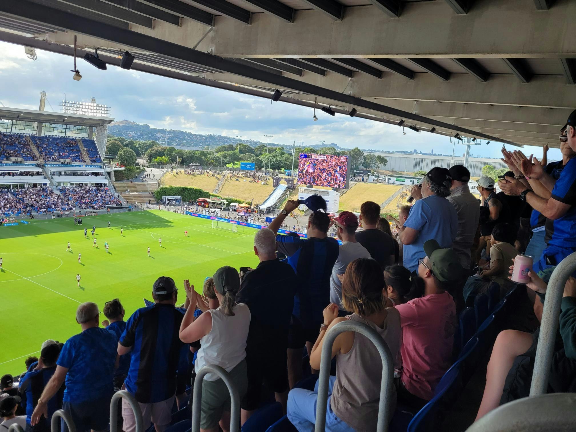 people cheering as they watch an Auckland fc football match